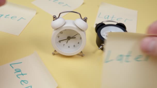 Alarm clock with a sticky note with text later. Procrastination, delay and urgency concept. - Footage, Video