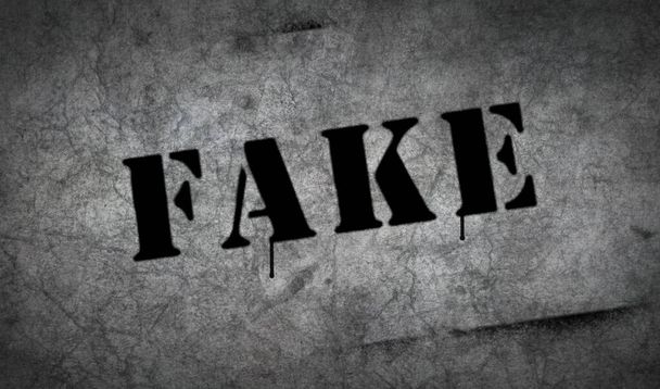 Fake spray painted on the concrete wall. Graffiti concept art of lie and false news sign. Airbrush paint with sign template in hand. City abstract artwork. - Photo, Image