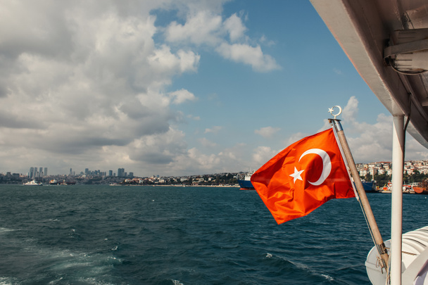 Rode Turkse vlag op schip in zee met Istanbul op achtergrond, Turkije  - Foto, afbeelding