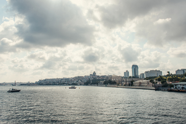Суда в море рядом с набережной на фоне облачного неба, Стамбул, Турция  - Фото, изображение