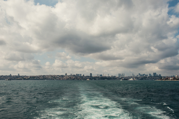 Widok z morza na wybrzeże Stambułu z zachmurzonym niebem na tle, Turcja  - Zdjęcie, obraz