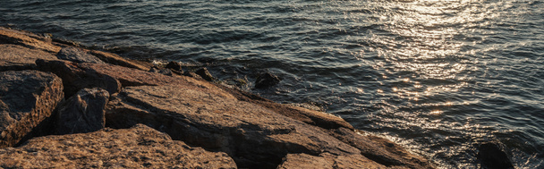 日没時の海岸の石、旗  - 写真・画像