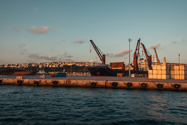 Тяжелая техника в морском порту Стамбула на закате, Турция  - Фото, изображение