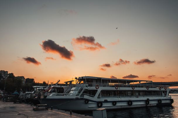 Statki zacumowane w pobliżu nabrzeża podczas zachodu słońca, Stambuł, Turcja  - Zdjęcie, obraz