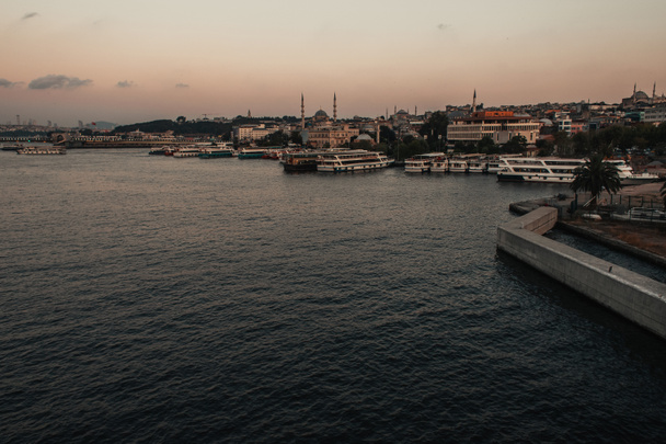 Navires sur l'eau de mer et bâtiments sur la côte d'Istanbul au crépuscule, Turquie  - Photo, image