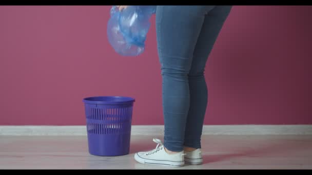 Γυναίκα βάζοντας νέα σακούλα σκουπιδιών σε κουβά κοντά στον τοίχο χρώμα - Πλάνα, βίντεο