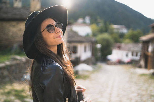 Щаслива жінка з чорним капелюхом насолоджується видом під час відпустки
 - Фото, зображення