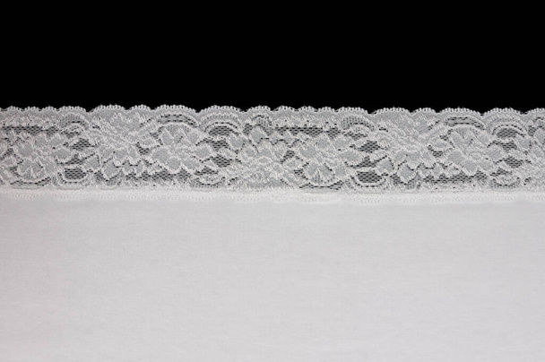 piece of white fabric with lace isolated on black background - Photo, Image
