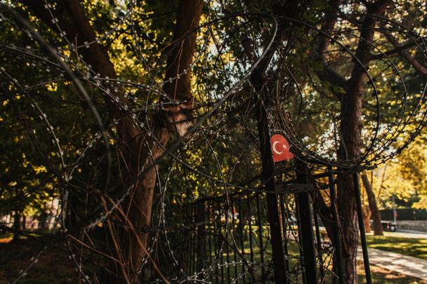 ogrodzenie z drutu kolczastego i flaga turecka w parku Stambuł, Turcja - Zdjęcie, obraz