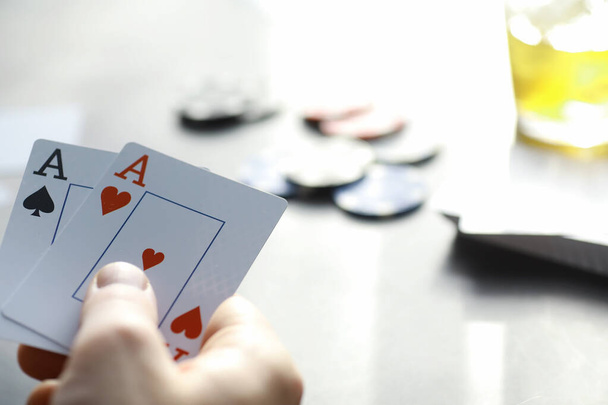 Uhkapeli Korttipelit rahasta. Texas Hold 'em pokeria. Kortit kädessä, pelimerkkejä, korttipakan alkoholin lasi. - Valokuva, kuva
