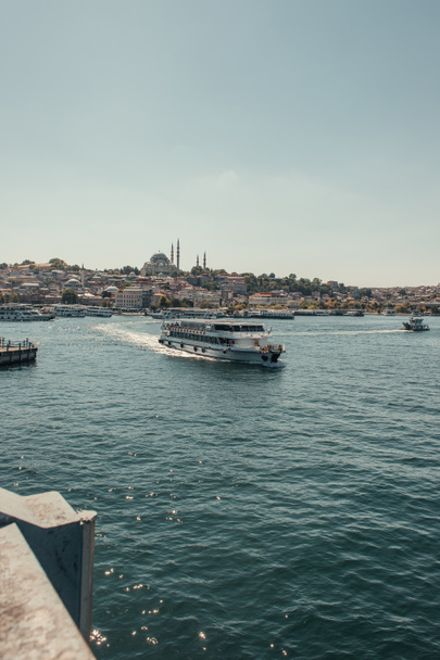 Boğazda yüzen turistik gemi ve demirli gemiler İstanbul ve Türkiye 'nin deniz önü manzarası - Fotoğraf, Görsel