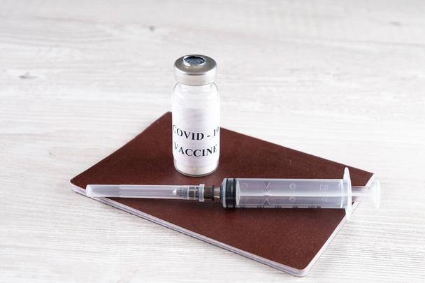 Coronavirus vaccine vials, syringe and passport. Corona virus treatment concept, injection, injection and clinical trials during a pandemic. Travel and travel concept during a pandemic. - Photo, Image