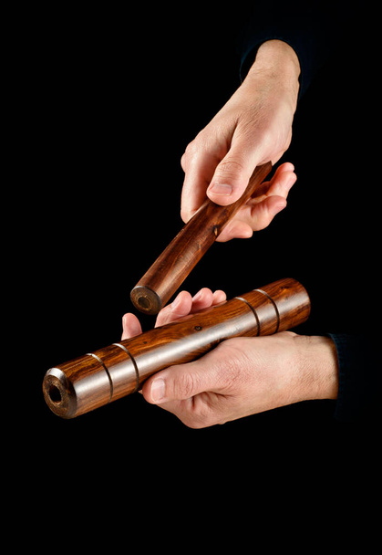 hands playing cuban clave percussion instrument on black background - Photo, Image