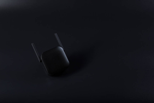 Zwarte wifi versterker close-up op zwarte backgr4ound met kopieerruimte. - Foto, afbeelding