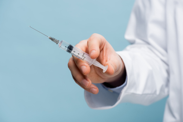 cropped view of doctor holding syringe in hand isolated on blue - Photo, Image