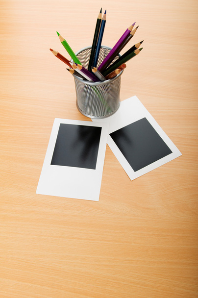 Fotos instantáneas en blanco y lápices en la mesa de madera
 - Foto, imagen