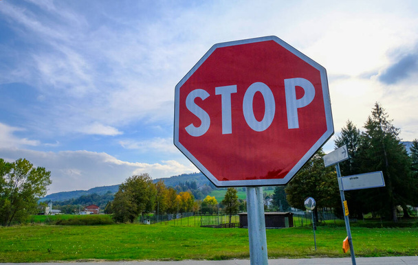 Stop liikennemerkki lähikuva poikki luonnon maiseman ja sininen taivas. - Valokuva, kuva