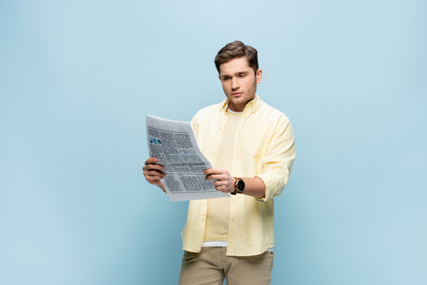 young man in shirt reading newspaper on blue - Photo, Image