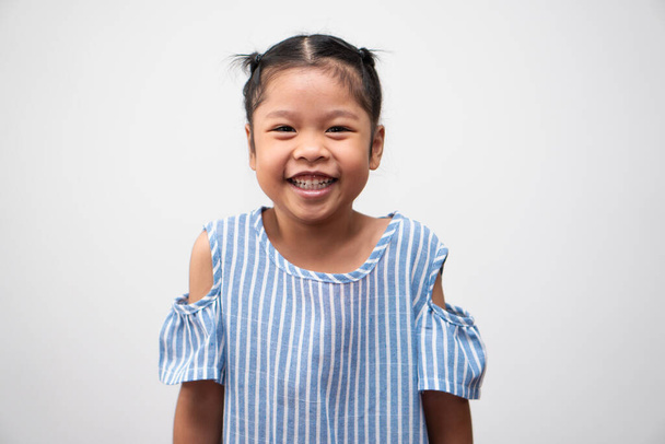 5 yaşındaki Asyalı bir çocuğun portresi ve izole edilmiş beyaz arka planda saç ve büyük bir gülümseme toplamak, O mutluluk, gençlikte parlaklık. - Fotoğraf, Görsel