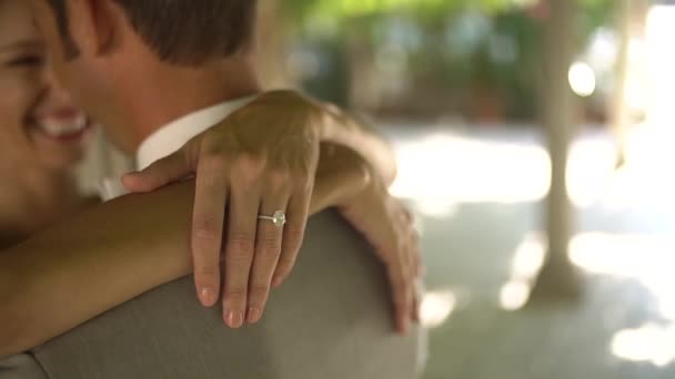 The bride hugs the groom and smiling on a shady street, close up - Footage, Video