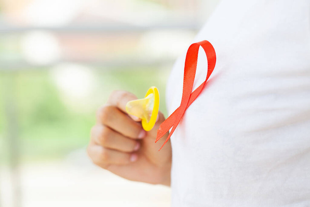 Houkutteleva liikenainen punainen nauha ja kondomi näkyy käsissä - Valokuva, kuva