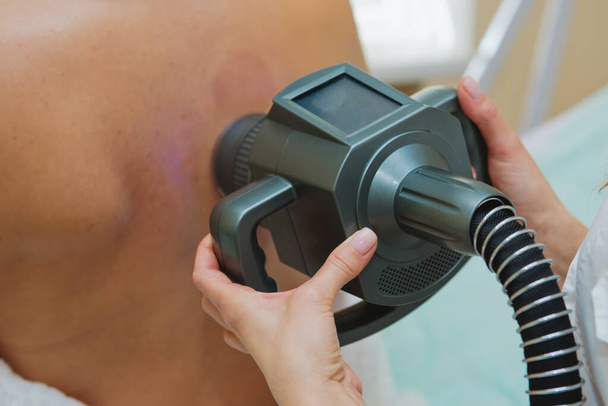 Cosmetologist fazendo massagem com aparelho nas costas femininas, close-up. - Foto, Imagem
