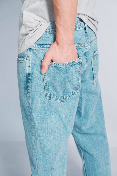 Poche arrière en jean bleu. Main d'homme dans la poche arrière du jean. Copier, espace vide pour le texte. - Photo, image