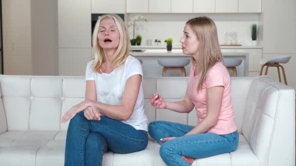 Ενοχλημένη ενήλικη κόρη μαλώνει την ξεροκέφαλη μητέρα της. Διαμάχη κόρης-μητέρας. Δύο διαφορετικές ηλικιακές οικογένειες γυναικών που έχουν αντίφαση - Πλάνα, βίντεο