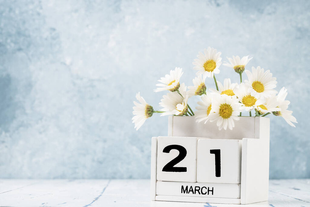 White Cube Kalender für März dekoriert mit Gänseblümchen Blumen auf blauem Hintergrund mit Kopierraum - Foto, Bild