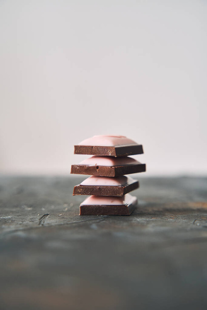 Enfoque selectivo en cuatro rebanadas de chocolate sobre un fondo oscuro. Foto de alta calidad - Foto, imagen
