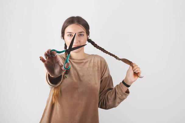 Μια γυναίκα κόβει τα μακριά μαλλιά της στο σπίτι. Καρδινάλιος συγκλονιστική αλλαγή - Φωτογραφία, εικόνα