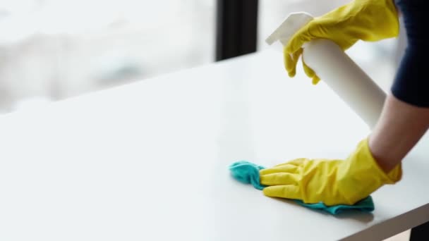 Límpialo todo. Mujer con guantes protectores amarillos limpiando y puliendo la superficie con un detergente en aerosol durante el día - Metraje, vídeo
