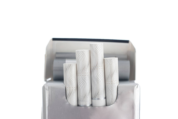 Paquete abierto de cigarrillos genéricos indescriptibles con cuatro piezas que sobresalen de cerca, plano de estudio aislado en blanco. - Foto, Imagen