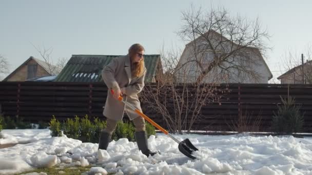 Женщина, убирающая снег - Кадры, видео