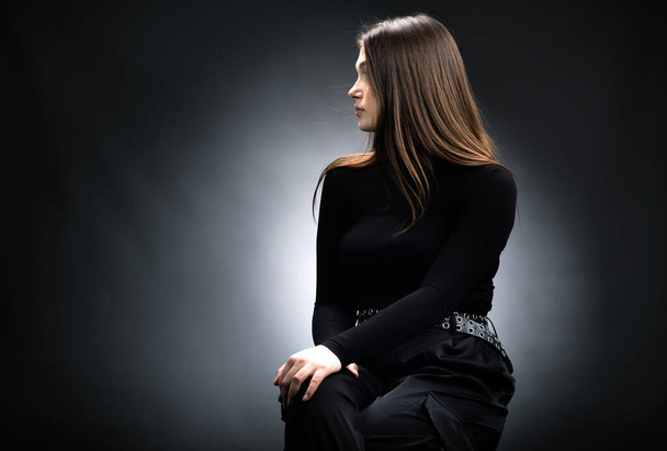 Portrét krásné teenager dívka v černém svetru. Černé pozadí - Fotografie, Obrázek