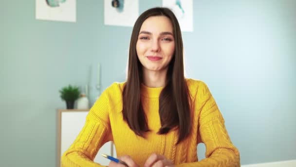 Mujer feliz en suéter amarillo sonriendo y charlando en webcam con sus seguidores - Metraje, vídeo