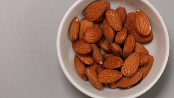Almonds nuts in a ceramic bowl on a wooden table - Footage, Video