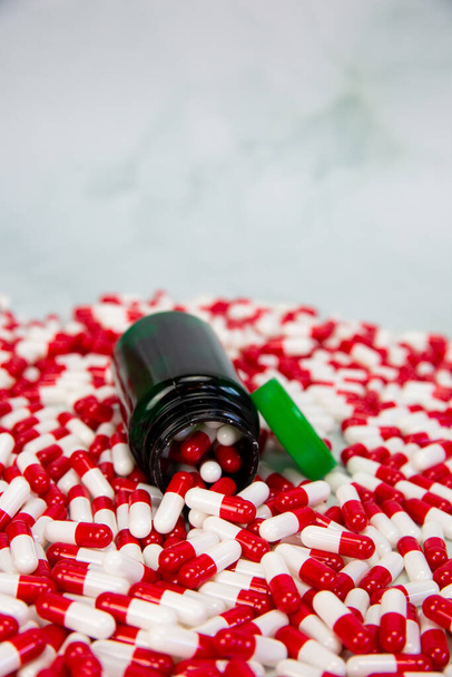 Μπουκάλι με κόκκινη και λευκή κάψουλα σε λευκό φόντο, Βιταμίνη, φάρμακα ή φαρμακευτική φαρμακευτική αγωγή υπόβαθρο, Υγεία, ιατρική και επιχειρηματική ιδέα - Φωτογραφία, εικόνα