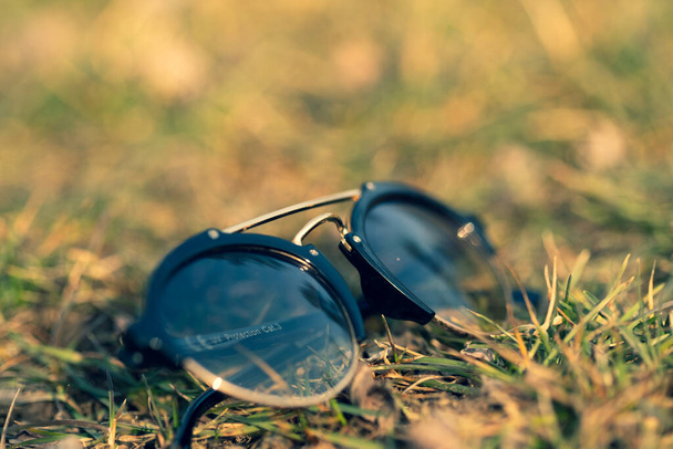 Okulary przeciwsłoneczne z okrągłą soczewką kręcą się na zewnątrz w słoneczny dzień. Skupienie selektywne - Zdjęcie, obraz