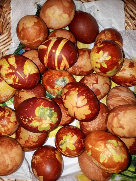 Házi készítésű hagyományos húsvéti tojás színezés segítségével különböző levelek, növények és virágok. Levelek és virágok mintája. - Fotó, kép