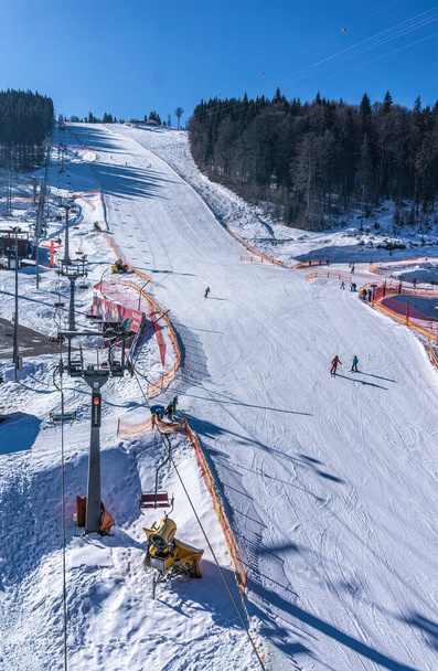 Pueblo de Palianytsa, región de Ivanofrankivsk, Ucrania - 14 de enero de 2021: Esquiadores y snowboarders descansan en la estación de esquí de Bukovel en las montañas de los Cárpatos, Ucrania. Descanso activo y vacaciones  - Foto, Imagen