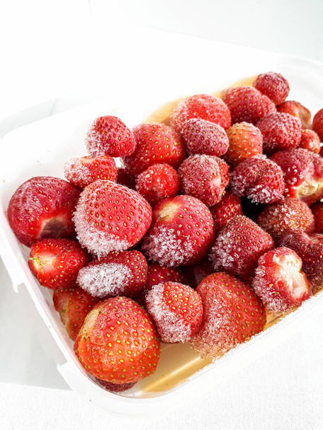 Заморожені і крижані садові полуниці з морозом на них з білим тлом, глибокий червоно-білий контраст, полуниця з морозильної камери
 - Фото, зображення