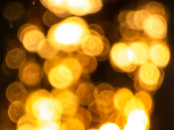 Gouden bokeh effect en bewust wazig zicht op zonlicht door bomen schaduwen. Goud en warm getint gevoel. wazige achtergrond met fotografische bokeh effect in mooie tinten. - Foto, afbeelding