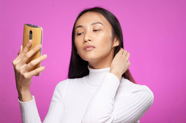 asian woman holding phone he communication technology internet pink background - Valokuva, kuva