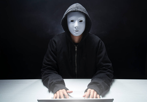 anonyymi hakkeri huppu ja naamio rikkoo arkaluonteisia tietoja levittämällä viruksia - Valokuva, kuva