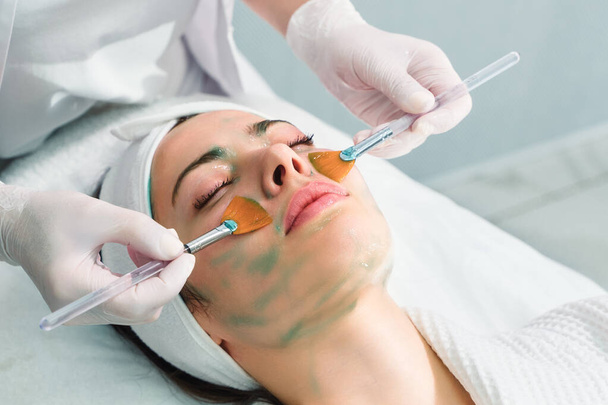 Péče o pleť. Na ženskou tvář na kosmetické klinice se nanáší maska. Zavřít - Fotografie, Obrázek