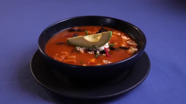 Salsa roja, corteza de cerdo y plato de aguacate en la mesa azul - Imágenes, Vídeo