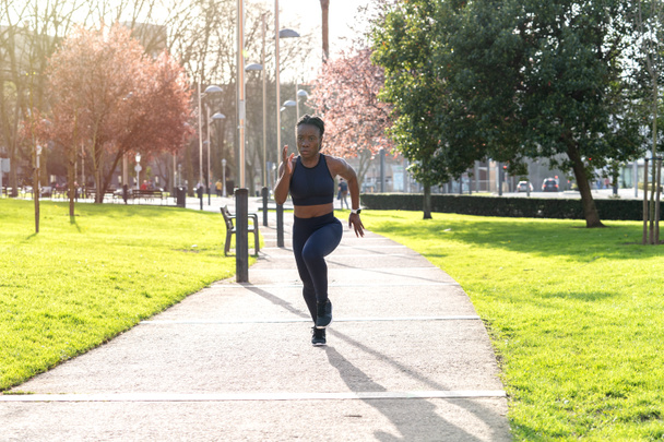 preto afro menina correndo no um público parque no por do sol - Foto, Imagem