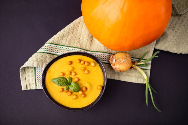 апельсиновый вкусный тыквенный суп на тёмном фоне - Фото, изображение