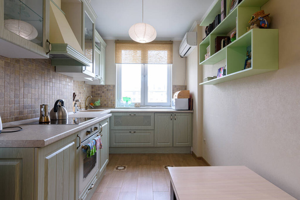 Het interieur van een lichte gewone keuken met een ruime keukenset - Foto, afbeelding